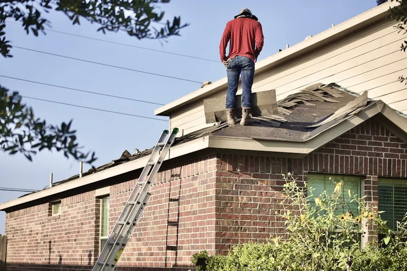 Professional roofer working on a residential roof in Oteen